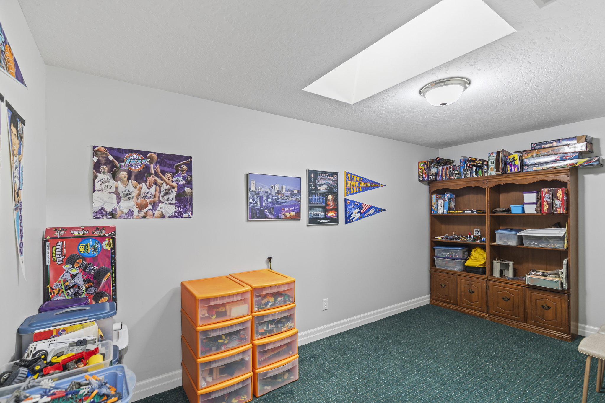 Game room featuring a skylight, dark carpet, and a textured ceiling