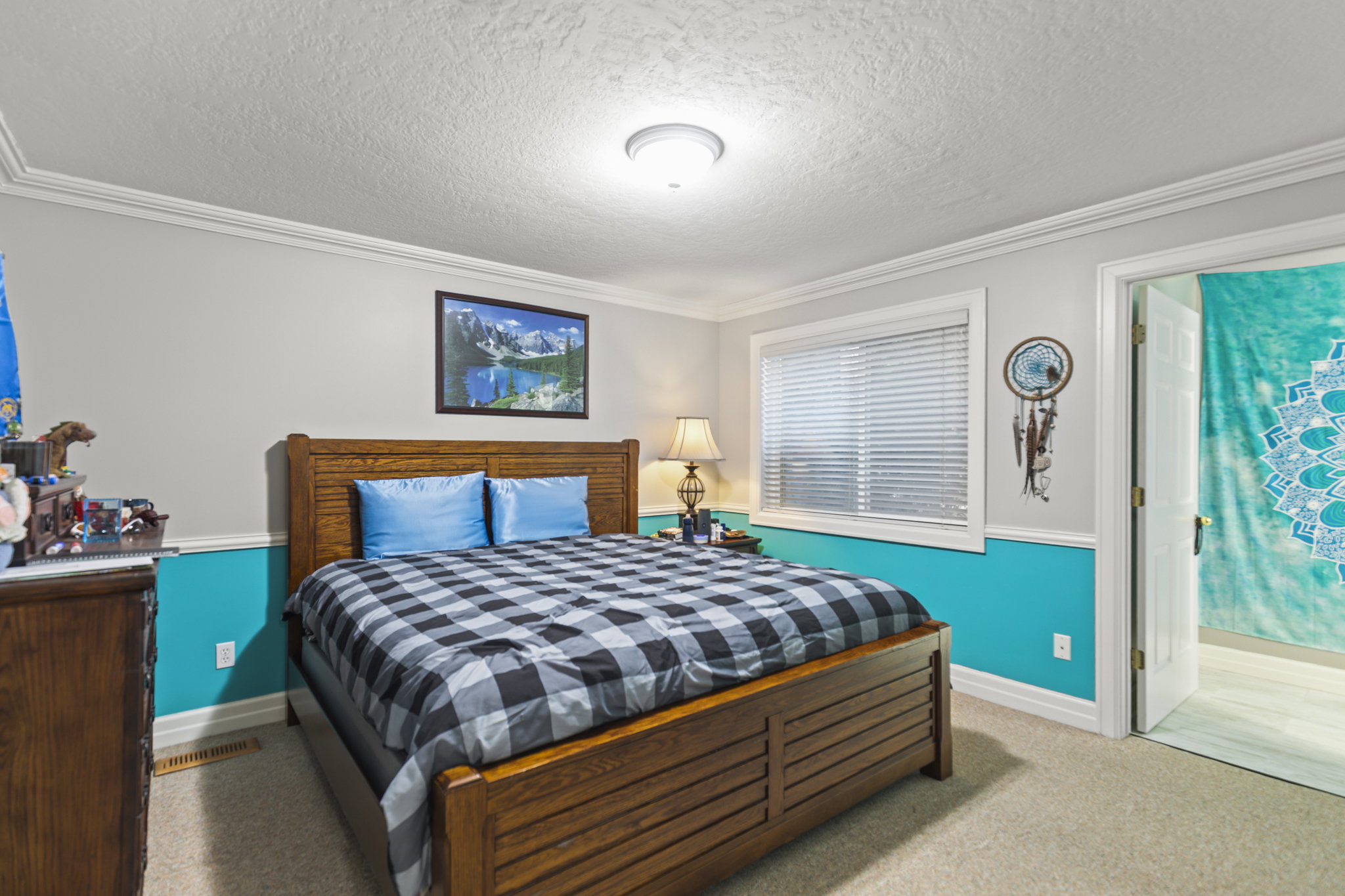 Bedroom featuring a textured ceiling, crown molding, and carpet