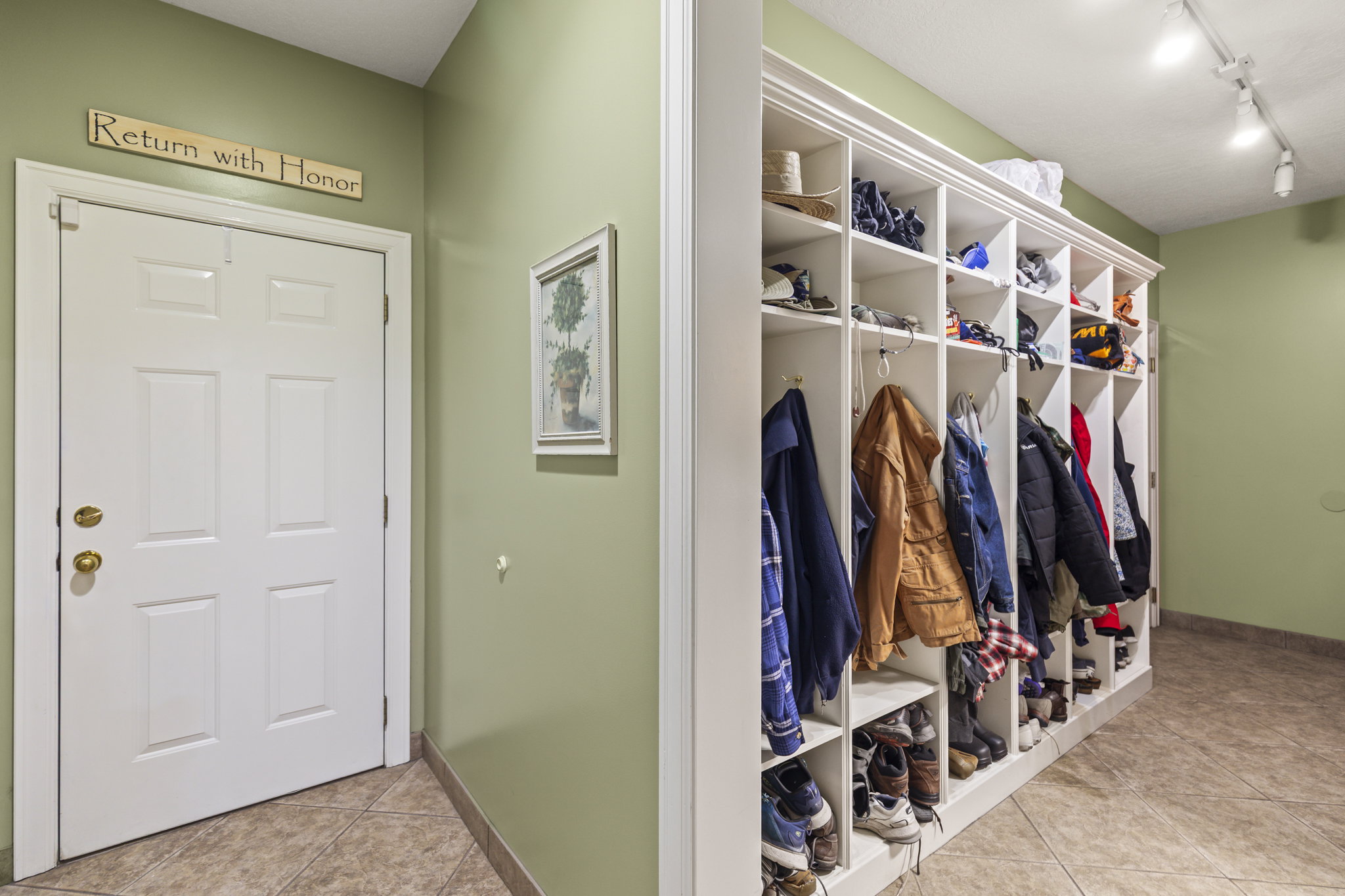 Mudroom with light tile patterned floors and rail lighting