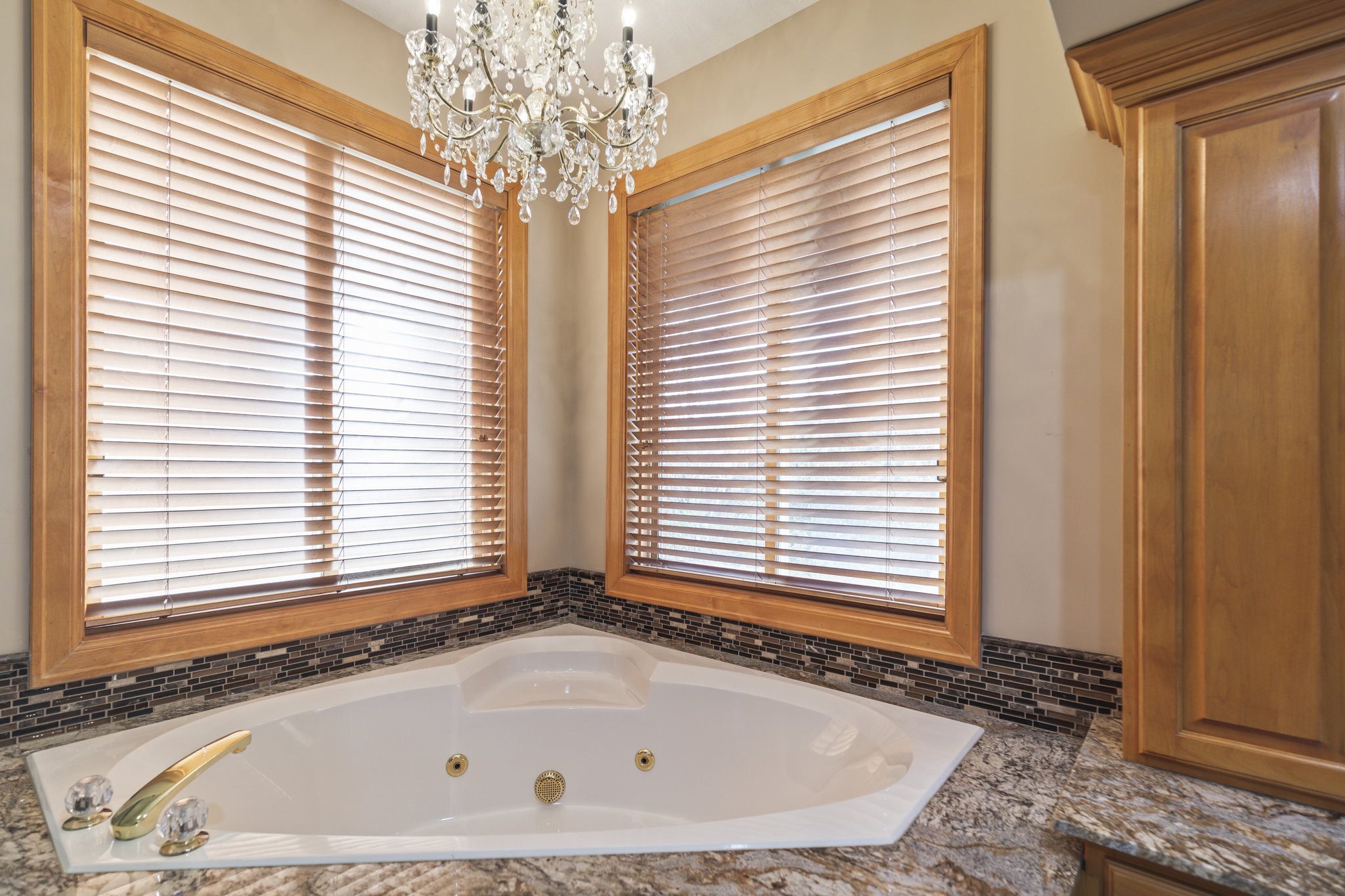 Full bath with hanging lights and a whirlpool tub