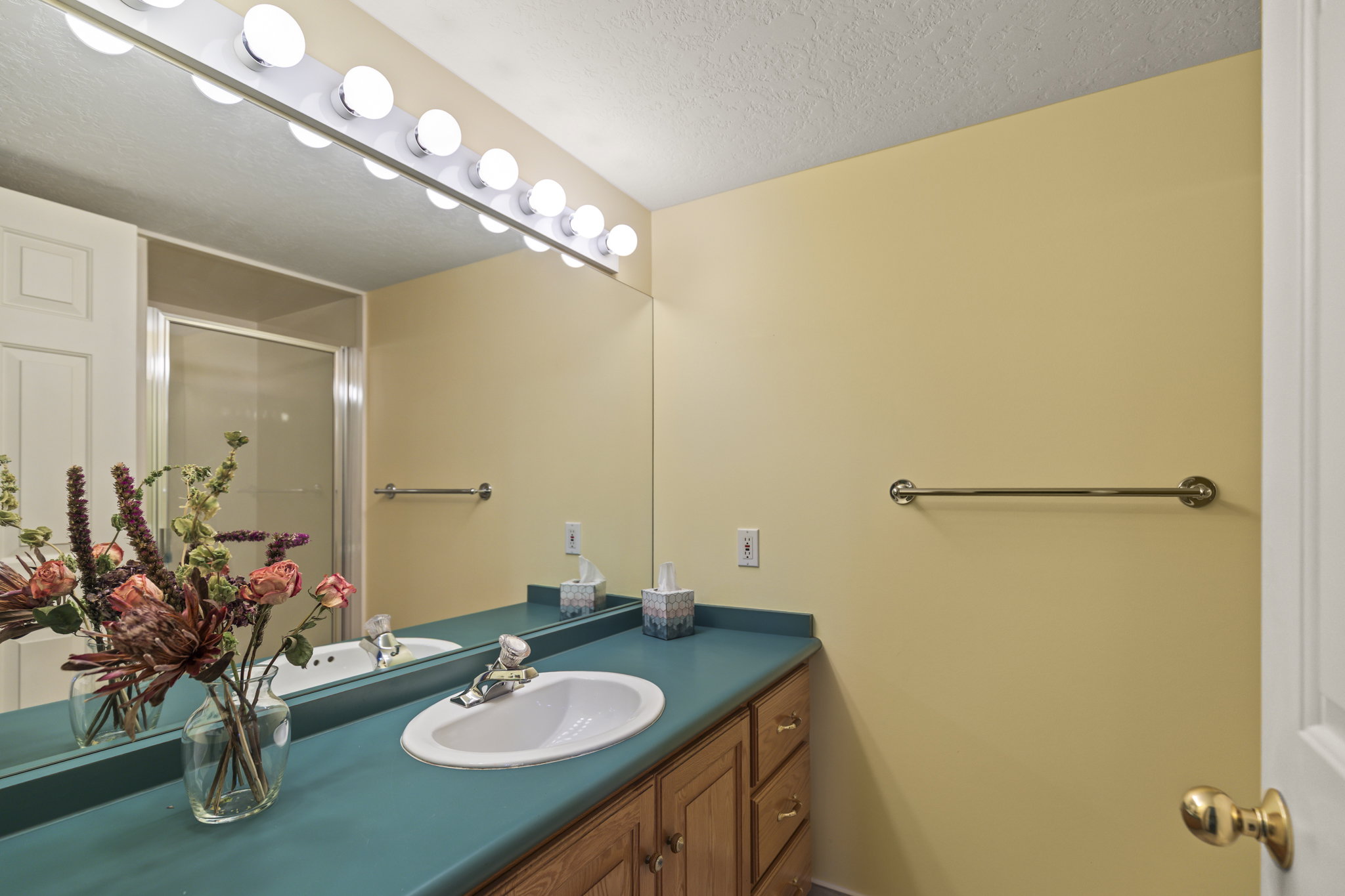 Full bath featuring vanity, a stall shower, and a textured ceiling