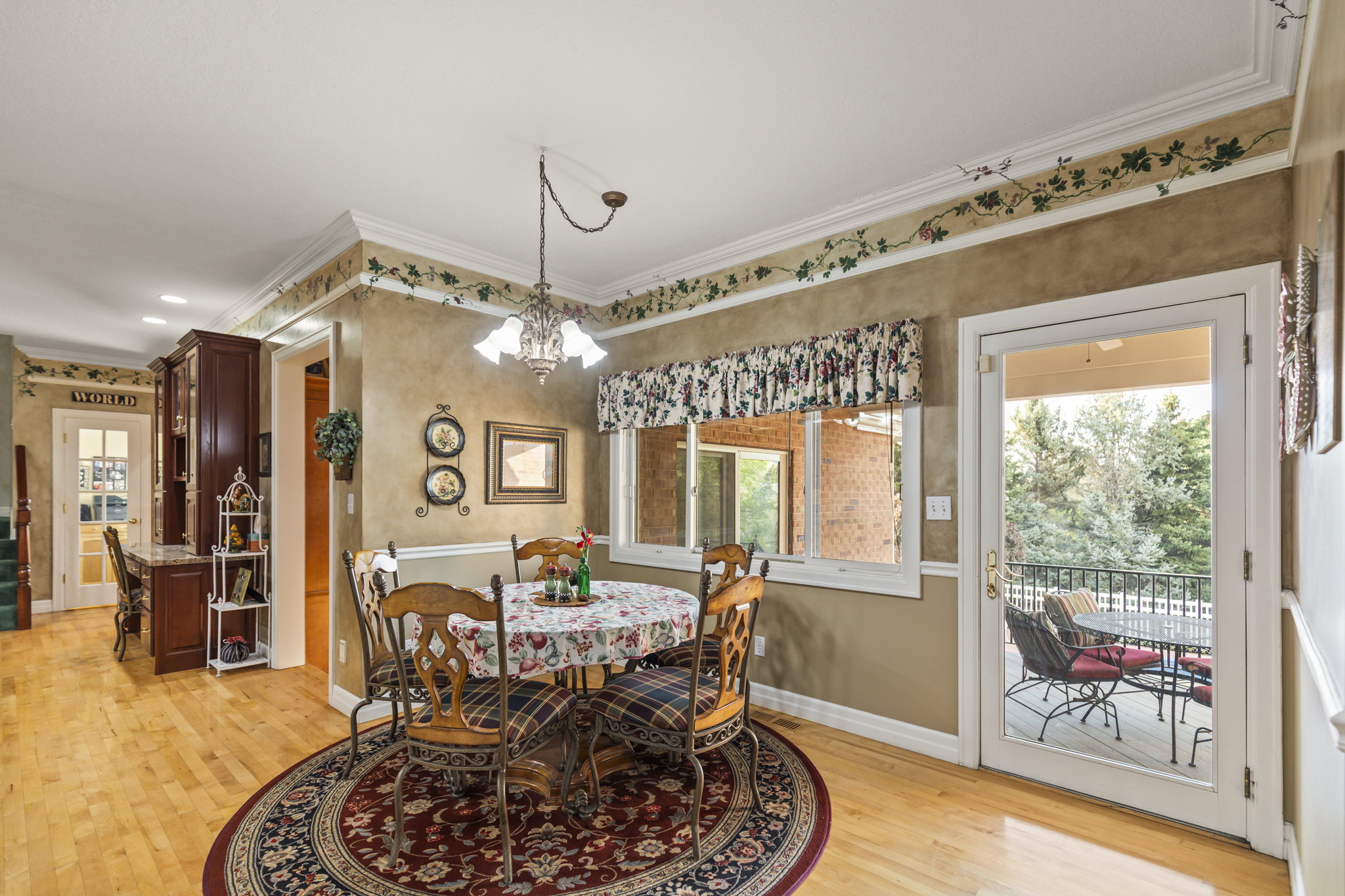 Dining room featuring light wood finished floors, crown molding, and suspended lighting