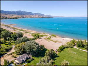 Aerial view towards the north east encompassing the cabin, shade trees, and sandy lake shore