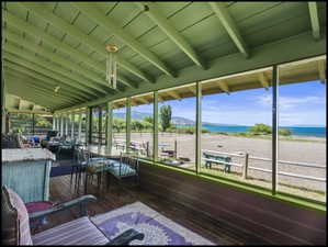 Huge screened porch featuring exposed beam ceiling, wood-finish flooring, and direct beach access and view of Bear Lake