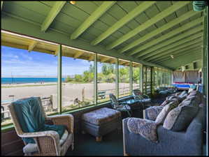 Screened porch featuring a vaulted ceiling and view of Bear Lake beachfront