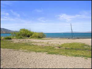 Shoreline property featuring sand and grass, with Bear Lake frontage and distant mountains