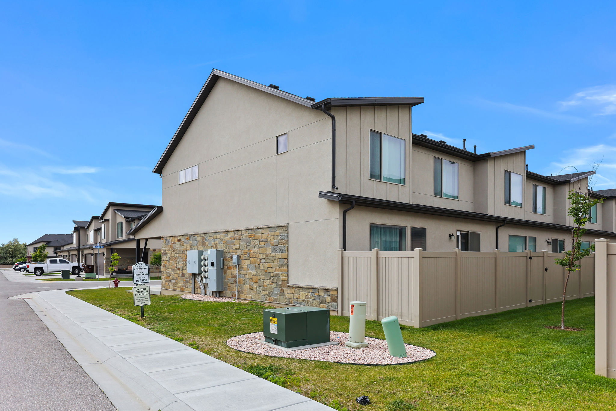 Contemporary multi-level townhome featuring stucco and stone veneer exterior
