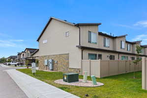 Contemporary multi-level townhome featuring stucco and stone veneer exterior