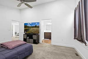 Spacious room featuring vaulted ceilings, a ceiling fan, plush carpet flooring, and white baseboards