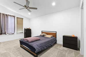 Bedroom featuring a vaulted ceiling with a ceiling fan, recessed lighting, and large windows with blinds
