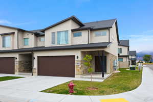 Modern townhome exterior with a light stucco finish and dark trim