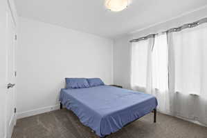 Room with neutral carpet, white walls, and a flush mount ceiling light