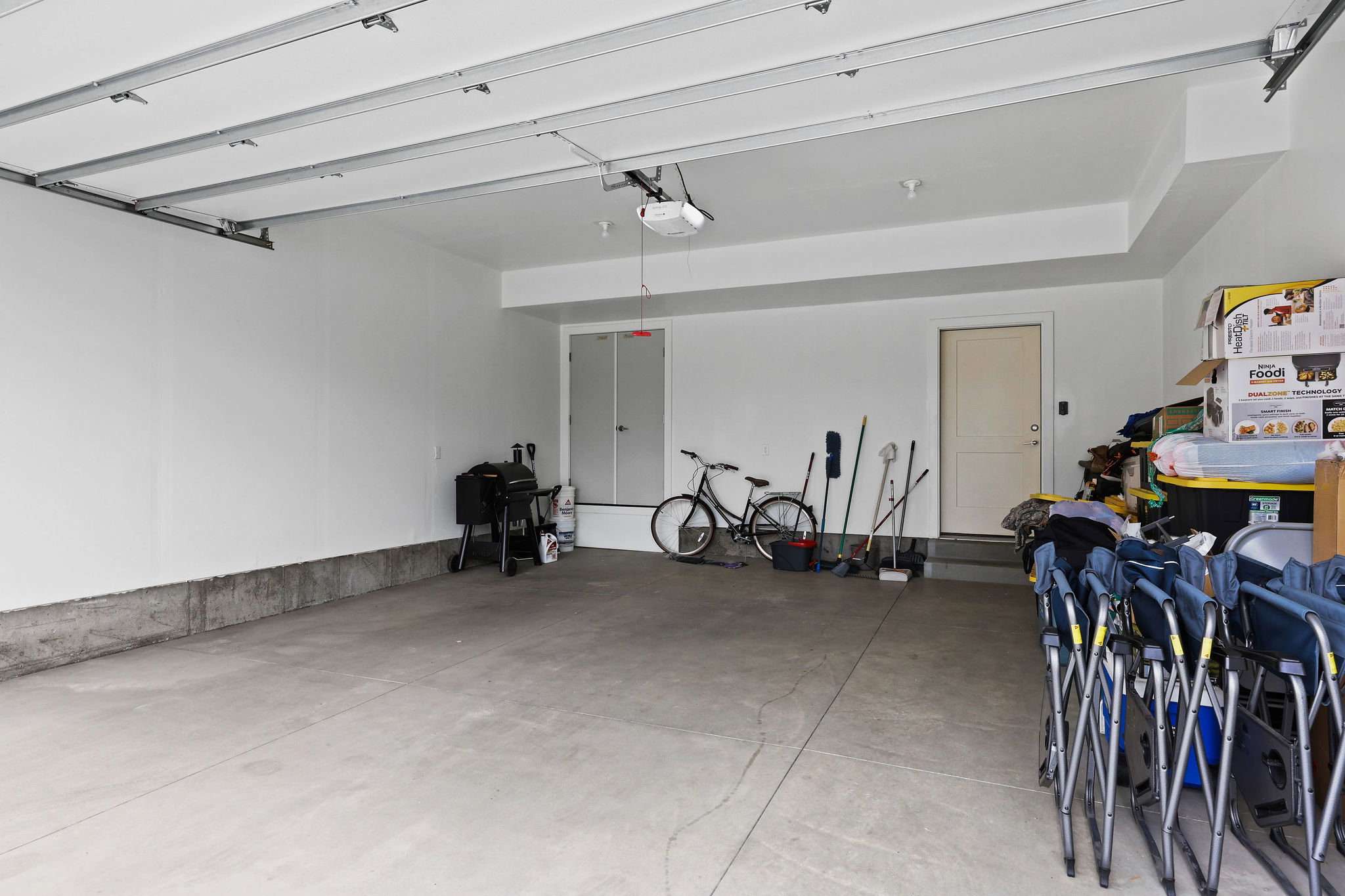 Spacious garage featuring a concrete floor, painted white walls, and an interior access door