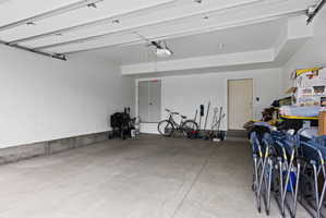 Spacious garage featuring a concrete floor, painted white walls, and an interior access door