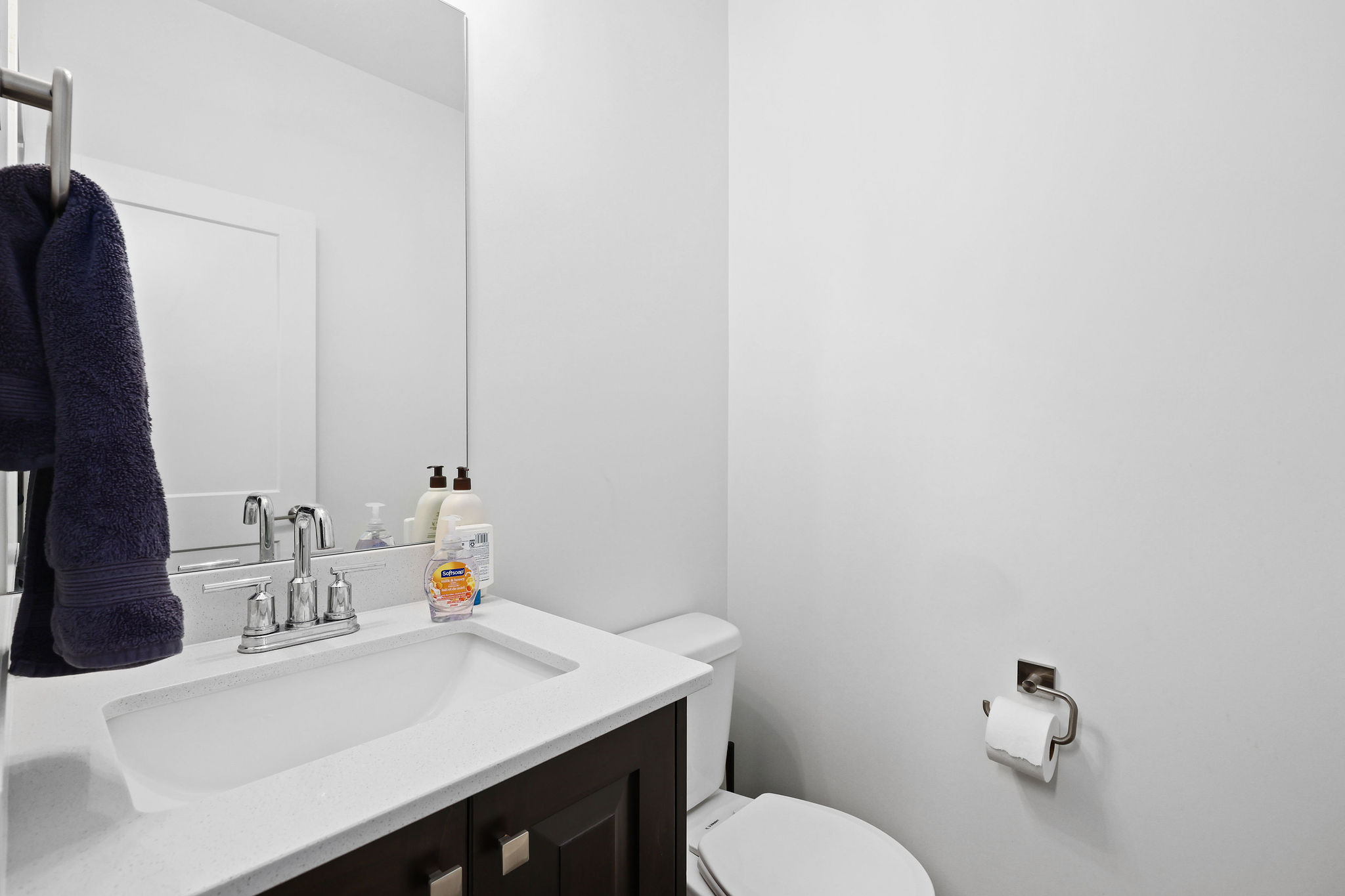 Bathroom vanity featuring a chrome faucet, integrated rectangular sink, and a light-toned countertop