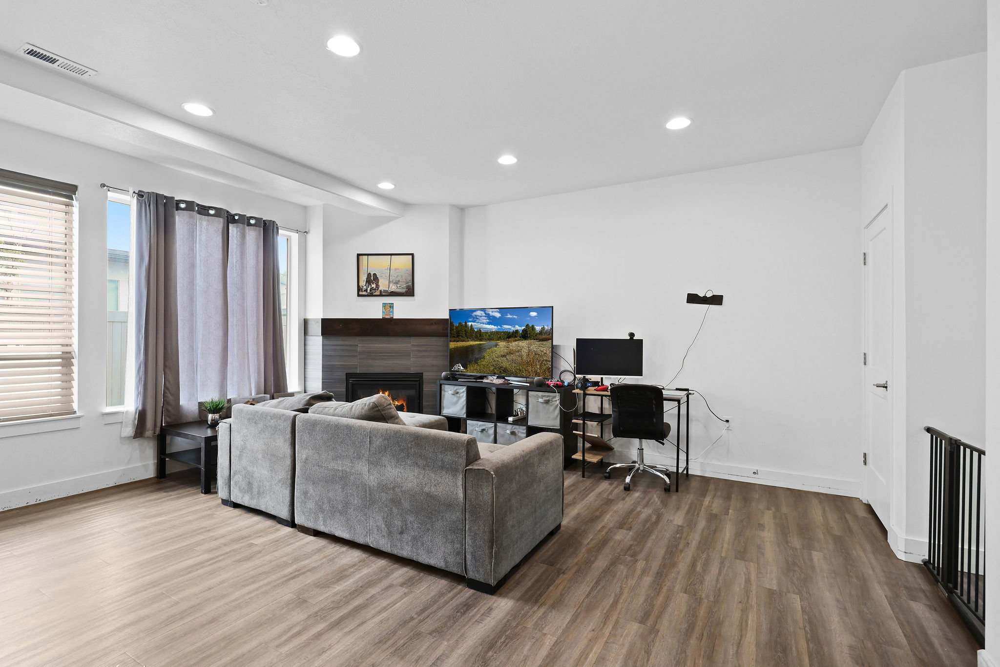Living area featuring wood-finish flooring, recessed lighting, and white walls