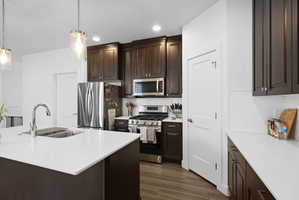 Modern kitchen featuring a large island with a stainless steel sink and gooseneck faucet