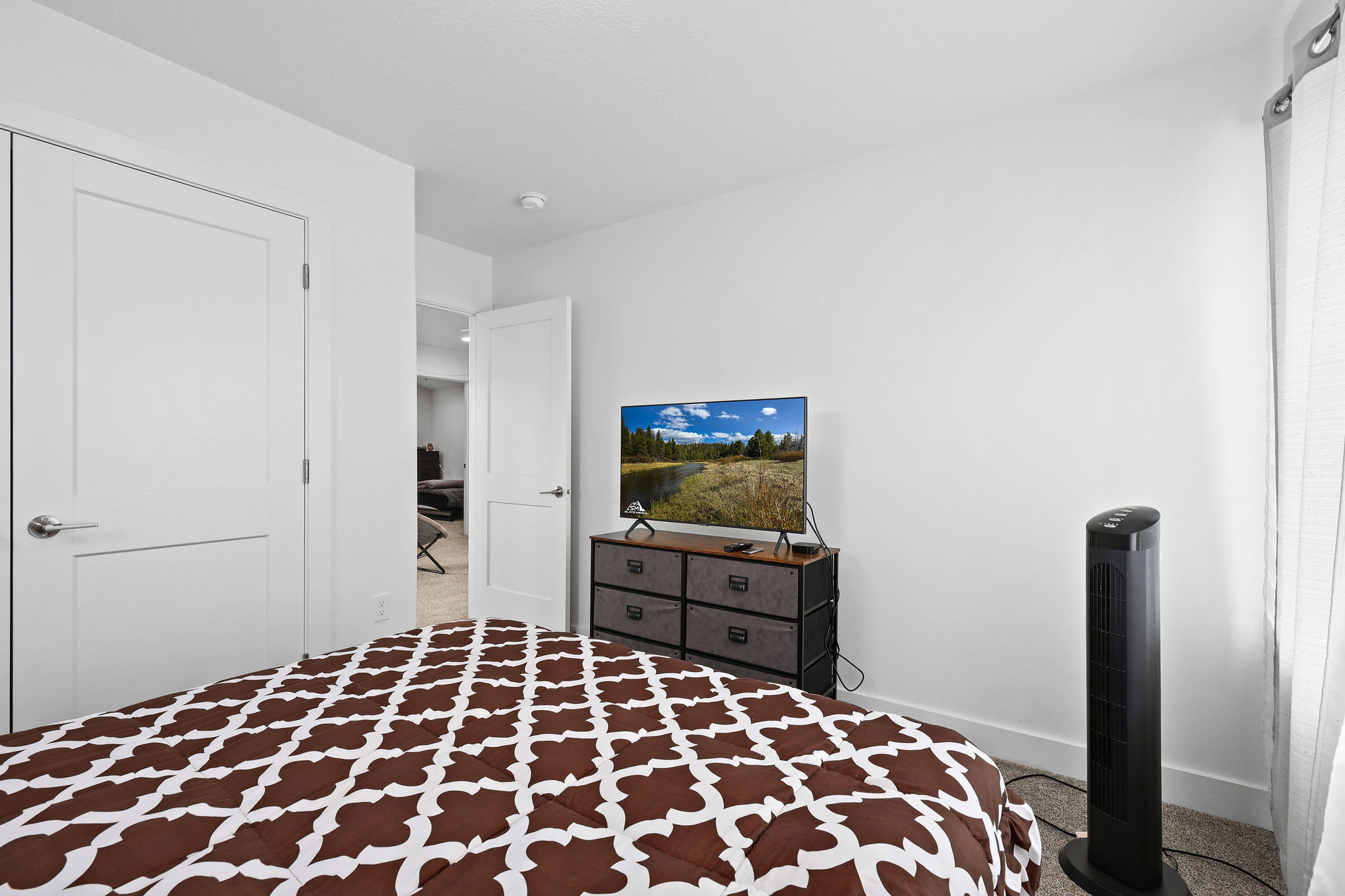 Room featuring white walls, modern flat-panel interior doors with brushed nickel hardware, and light-colored carpeting