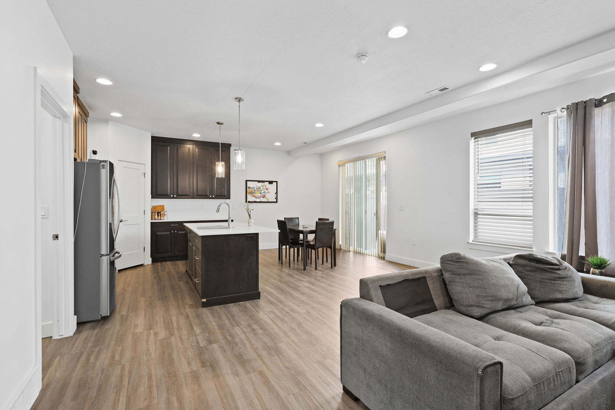Open-concept interior featuring wood-finish flooring, recessed lighting, and white walls