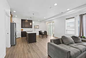 Open-concept interior featuring wood-finish flooring, recessed lighting, and white walls