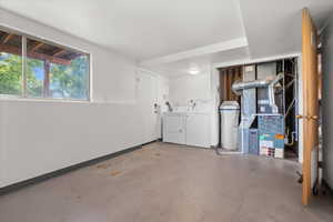 Utility room featuring a window, painted concrete flooring, a washer and dryer, and exposed HVAC system