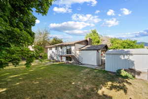 Spacious backyard with a grass lawn, mature trees