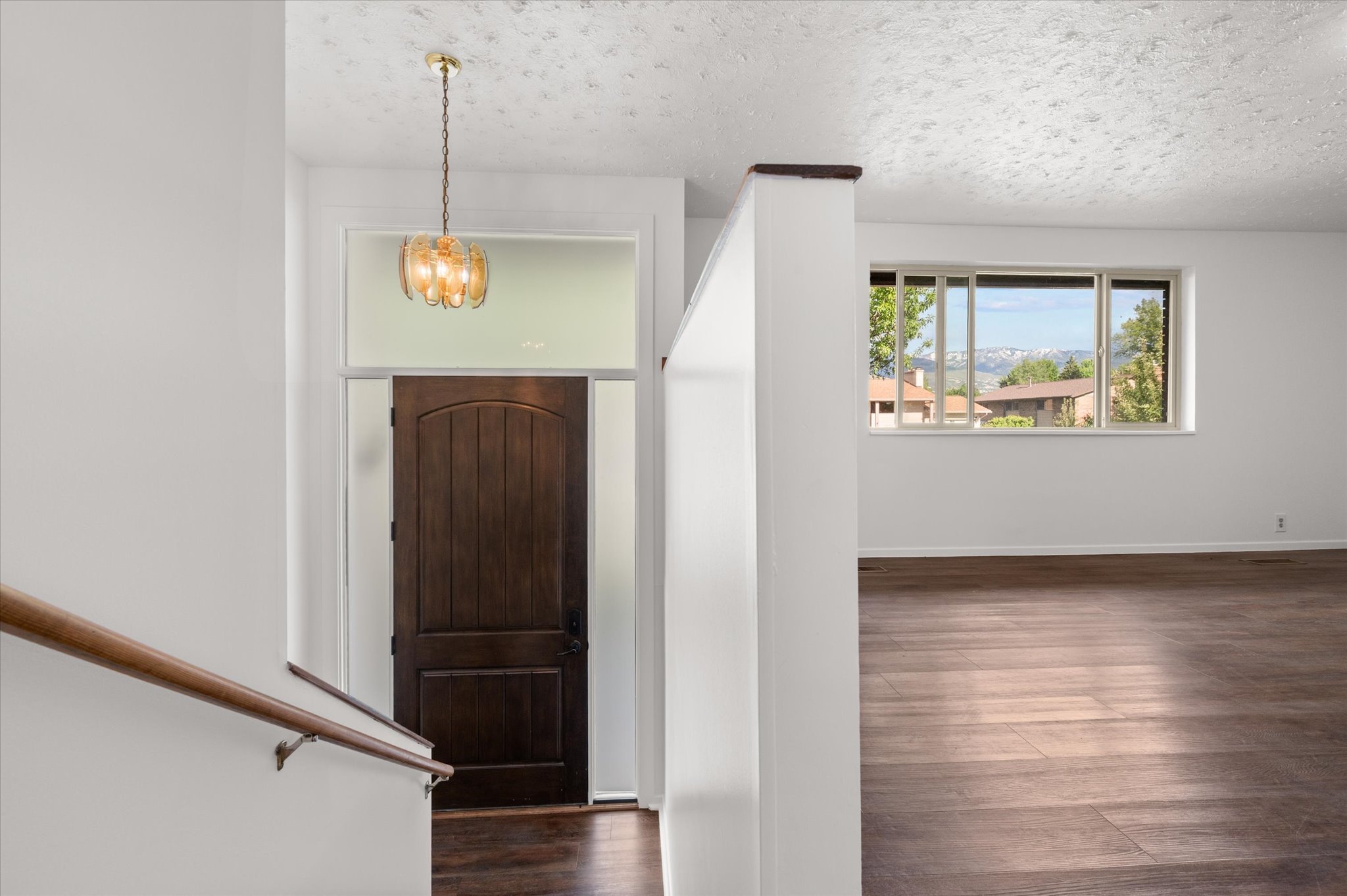 Arched entry door with transom window and contemporary chandelier