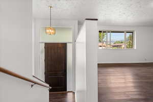Arched entry door with transom window and contemporary chandelier