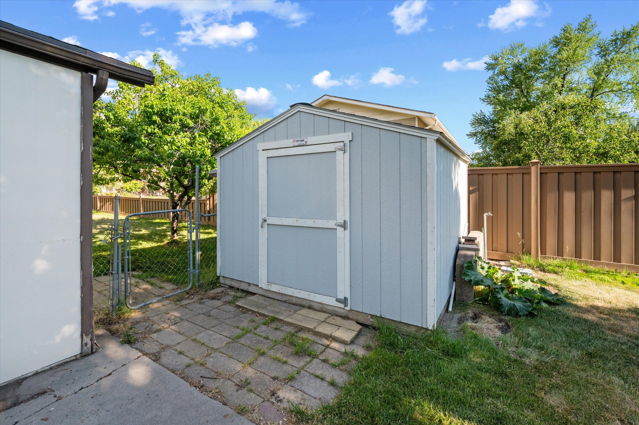Outdoor storage shed with a light blue finish and white trim