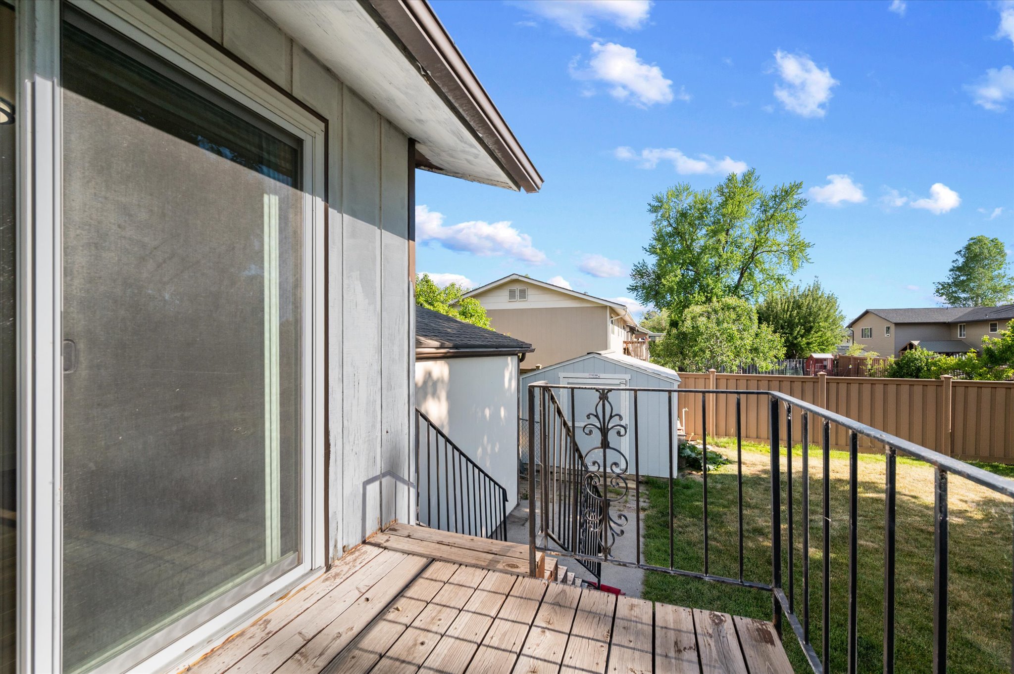 Exterior deck featuring wood-finish flooring and a black wrought iron railing