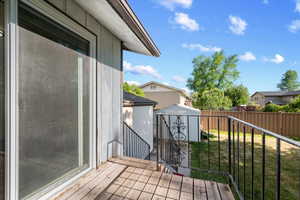 Exterior deck featuring wood-finish flooring and a black wrought iron railing