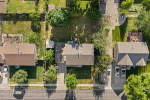 Property featuring a substantial private backyard with mature landscaping and ample green space, complemented by a paved driveway and an additional side yard