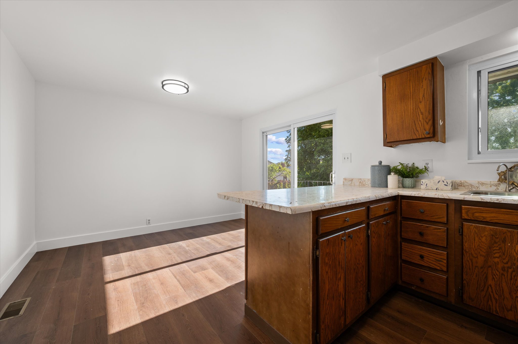 Kitchen area featuring wood-finish flooring and white walls