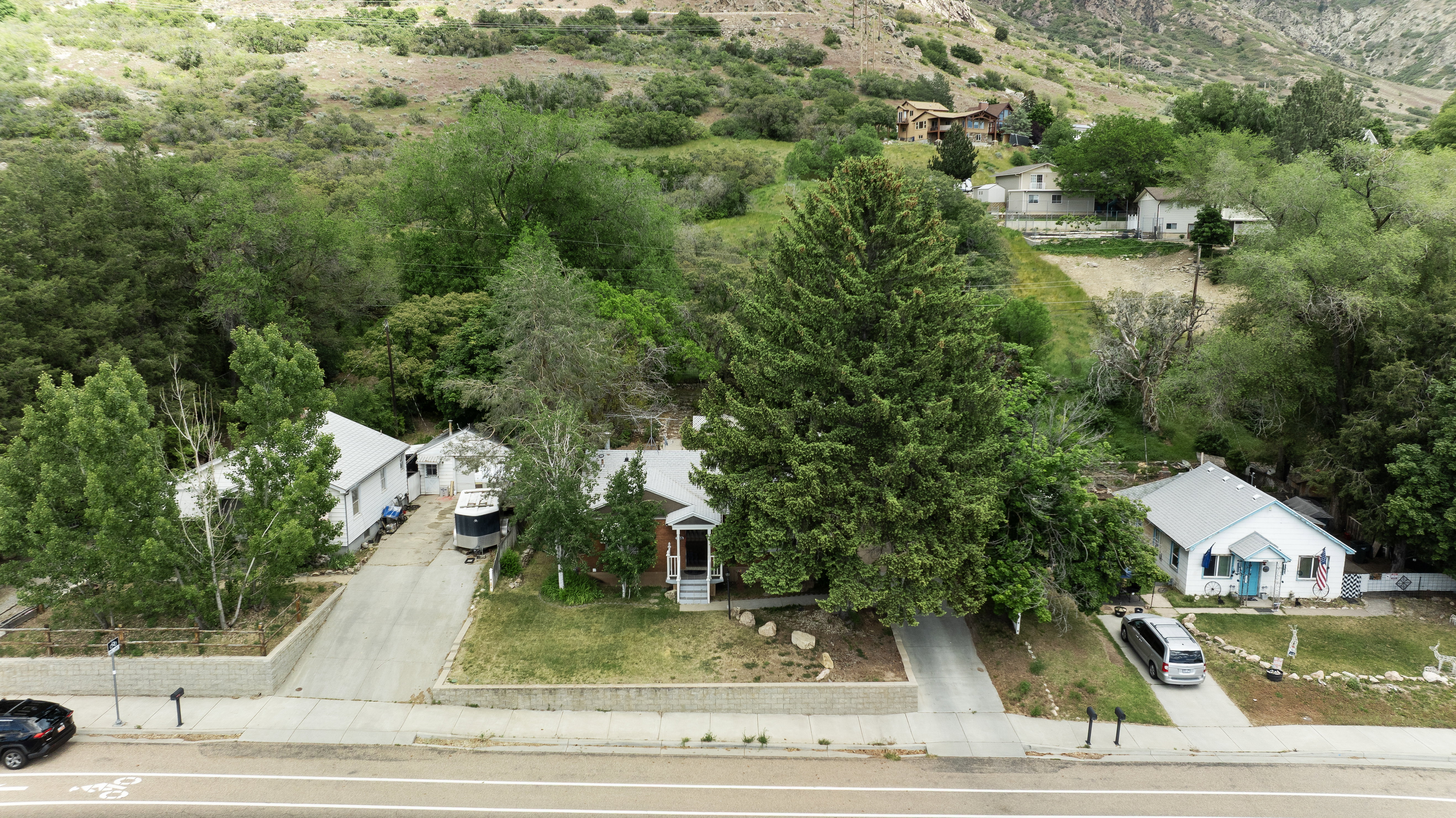 Residential property featuring a sloping terrain and a backdrop of verdant hillsides
