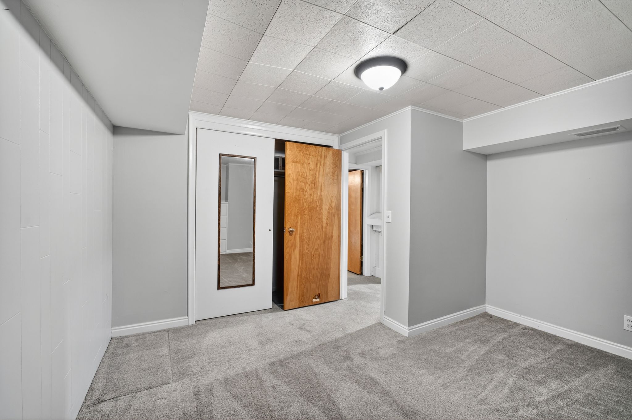 Interior space featuring plush grey carpeting and white baseboards