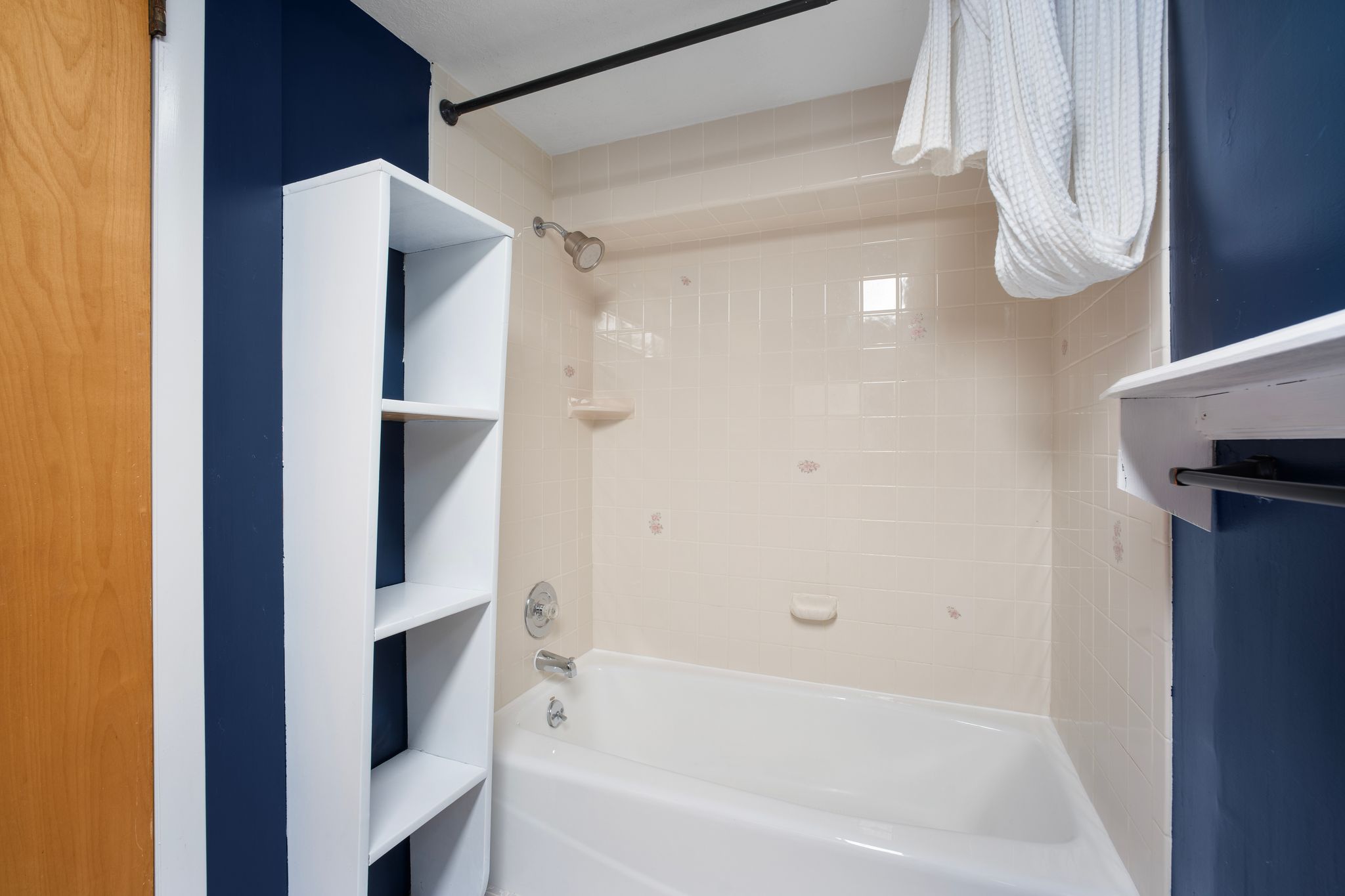 Bathroom featuring a built-in white bathtub, subway tile surround, and chrome fixtures