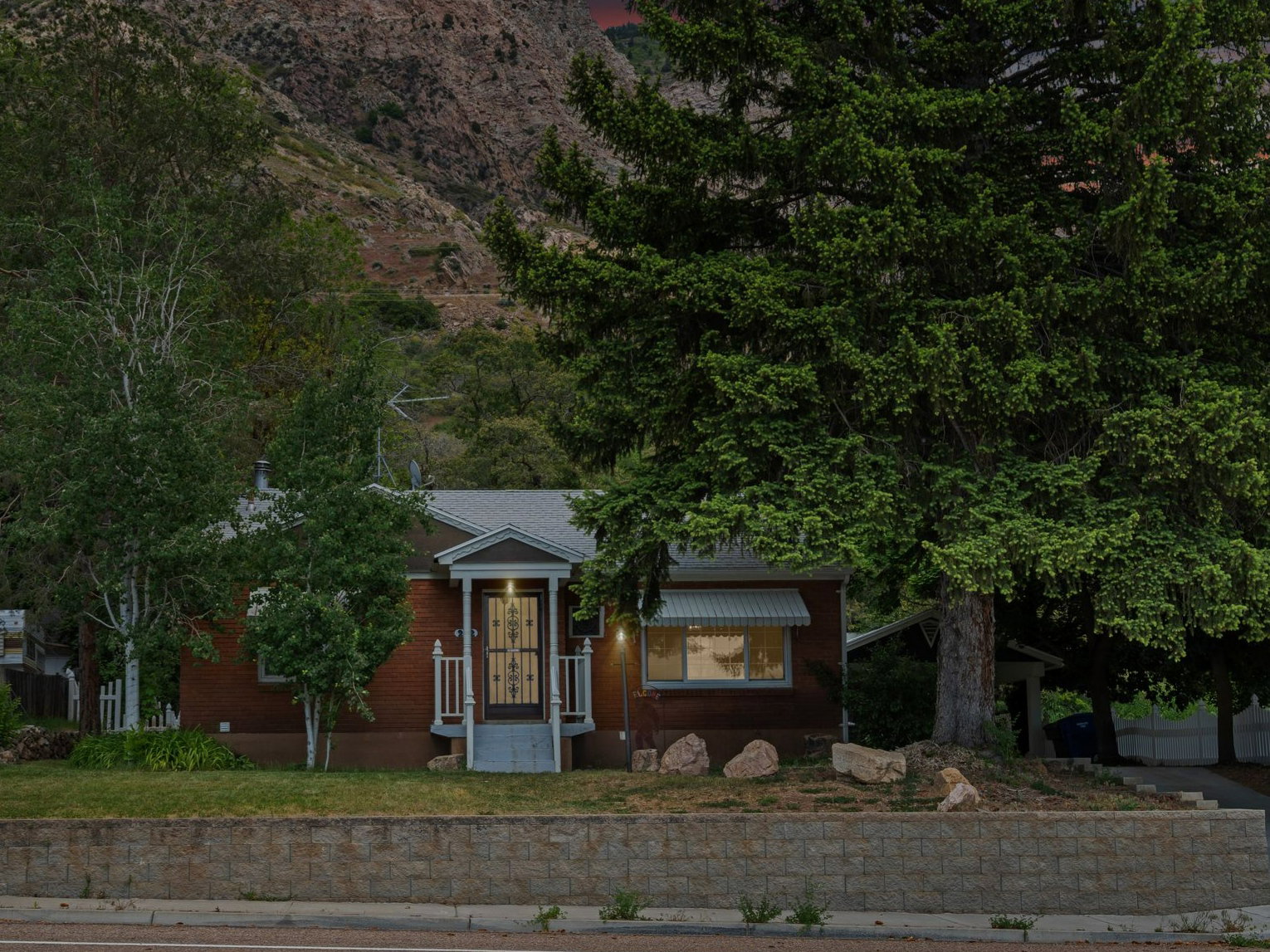 Brick facade residence with a prominent mature evergreen tree