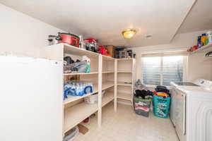 Utility room featuring extensive built-in shelving, a recessed window, vinyl tile flooring, and a flush mount ceiling light
