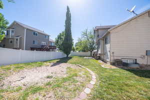 Expansive backyard featuring a white vinyl fence and a stepping stone path