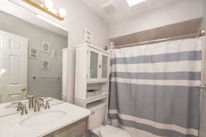 Bathroom featuring a vanity with a white countertop and undermount sink, brushed nickel fixtures, a full-width mirror, and overhead lighting