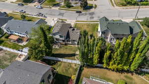Spacious rear yard featuring mature trees, a white perimeter fence, and ample green space