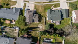 Expansive property featuring a large concrete driveway, mature trees, and a spacious backyard area