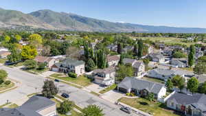 Neighborhood setting with mature trees and mountain backdrop