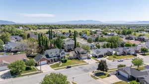 Residential neighborhood with varied architectural styles, mature trees, and mountain backdrop