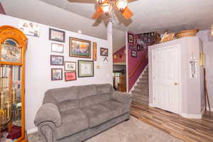 Recessed lighting illuminates the wood-finish flooring and staircase with carpeted treads
