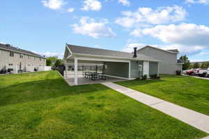 Community picnic area featuring a covered patio, paved walkway, and expansive green space
