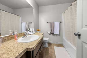 Full bathroom featuring a laminate countertop with an integrated sink, chrome faucet, and expansive wall mirror