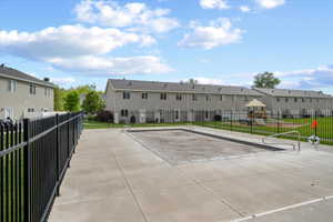 Community outdoor swimming pool with concrete surround and black metal fencing