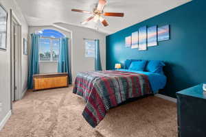 Carpeted room featuring a vaulted ceiling and an arched window