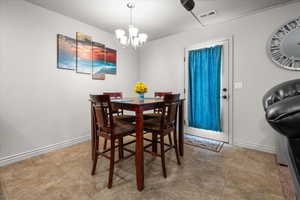 Dining area featuring tile flooring, a white exterior door, and a multi-light ceiling fixture